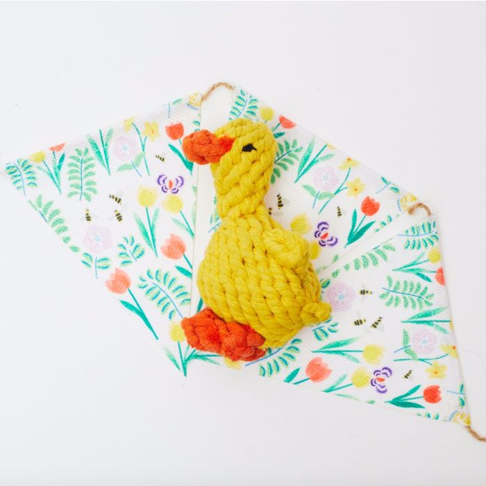 A duck rope toy on a flowery background